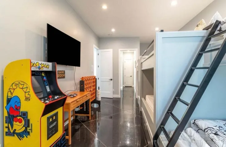 Recessed lighting, wood-finish flooring, two sets of built-in bunk beds, and a wall-mounted display