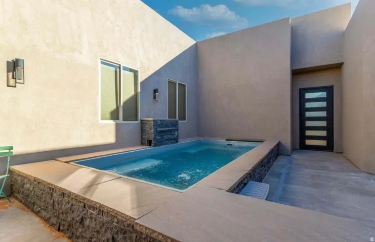 Private courtyard featuring a rectangular pool and integrated spa