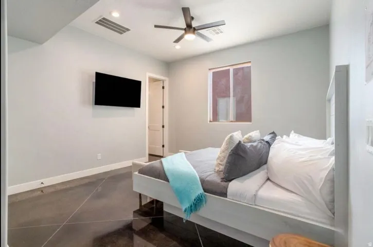 Polished concrete flooring, recessed lighting, ceiling fan, and white paneled door