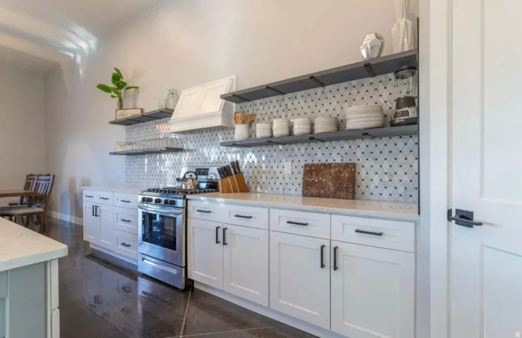 Stainless steel gas range with a white vent hood