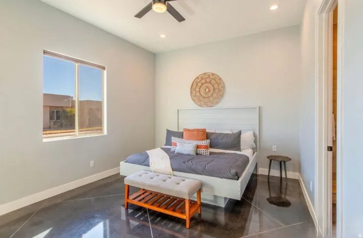 Recessed lighting, ceiling fan, high ceilings, large window, and polished concrete flooring