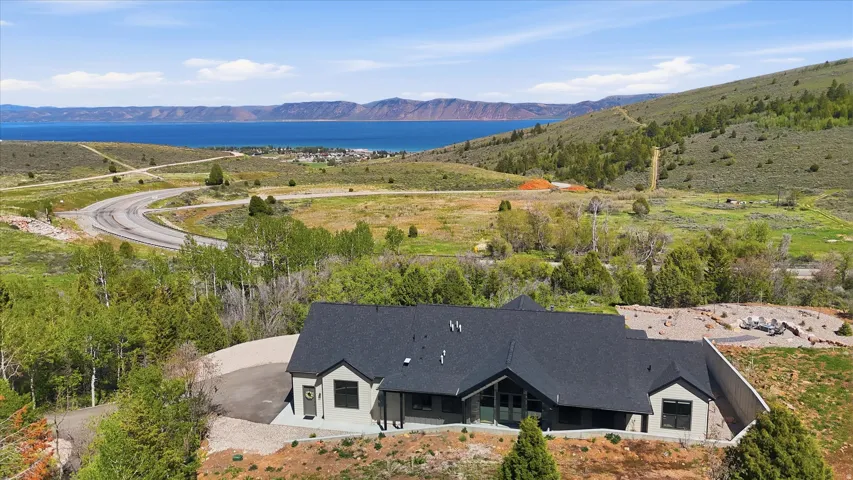 Modern single-story residence featuring a dark gray shingle roof and light gray siding