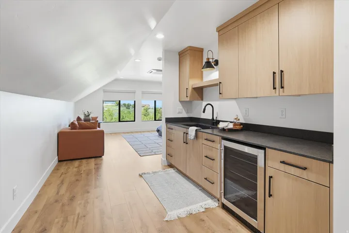 Attic space featuring wood-finish flooring, recessed lighting, and sloped ceilings