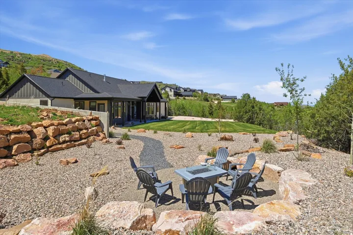 Outdoor living space featuring a gravel fire pit area with natural rock accents