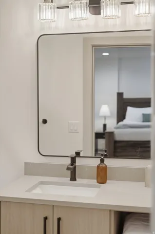 Bathroom vanity featuring a light-toned countertop with an integrated rectangular sink