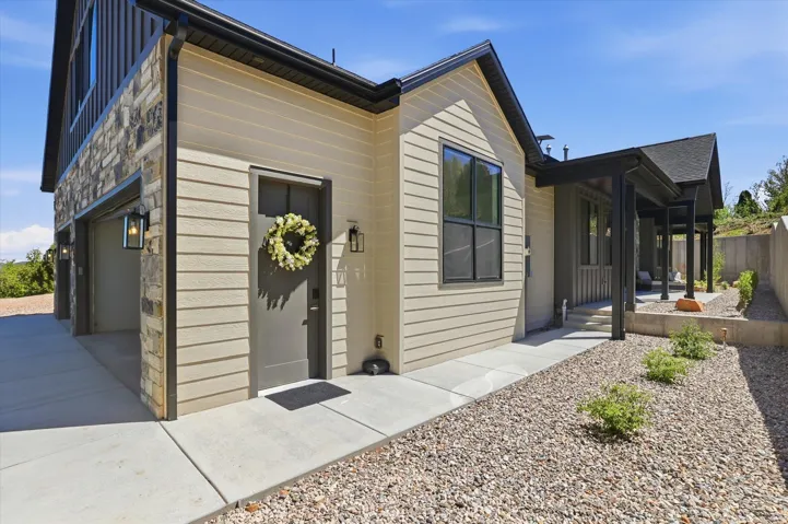 Modern facade featuring a stone veneer accent, horizontal siding, and a covered entry