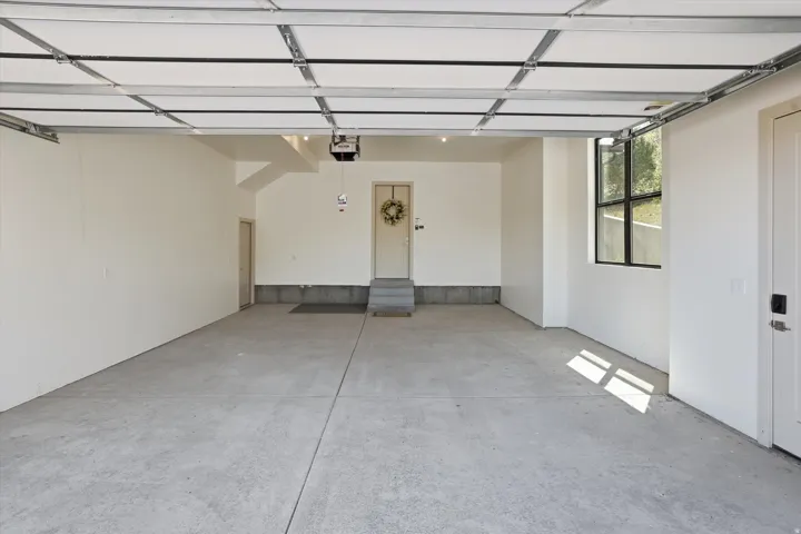 Spacious garage featuring a concrete floor, bright white walls, and an overhead garage door mechanism