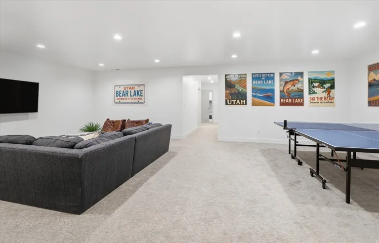 Spacious recreation area featuring recessed lighting, light-toned carpeting, and white painted walls