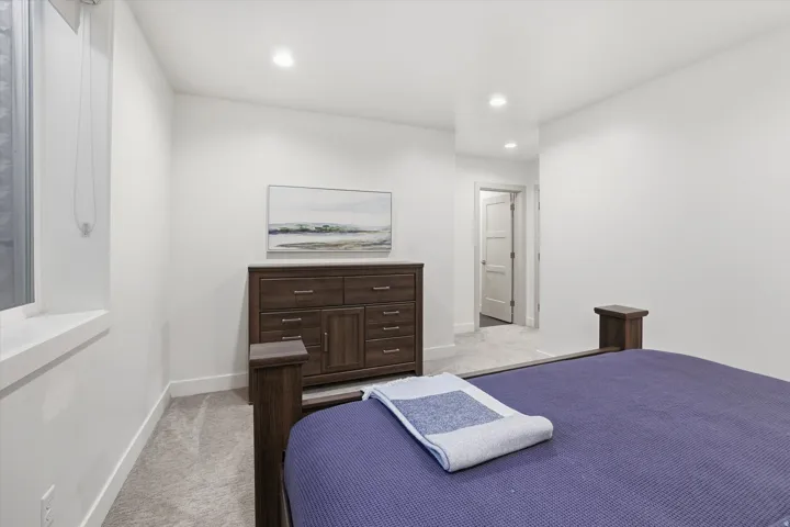 Bedroom featuring plush gray carpeting, recessed lighting, and crisp white walls