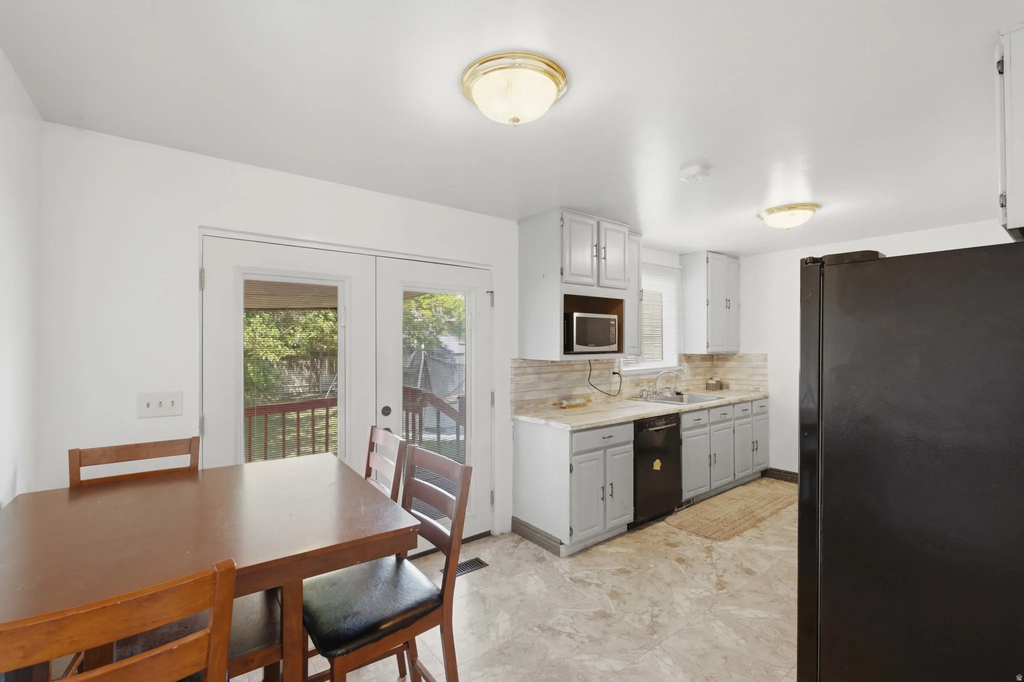 Kitchen with light-toned cabinetry, a built-in microwave, and a window above the sink