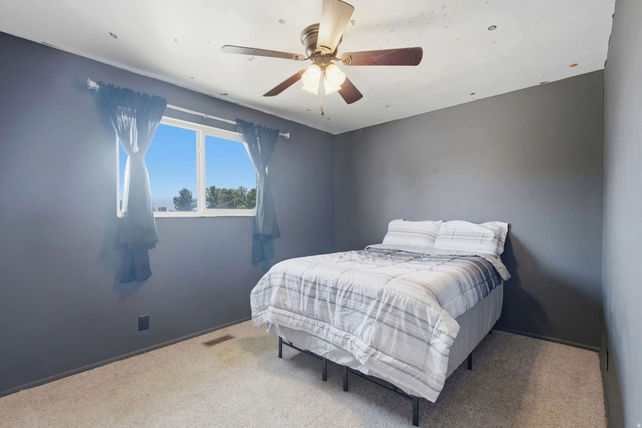 Room featuring light-toned carpeting and a window with outdoor scenery