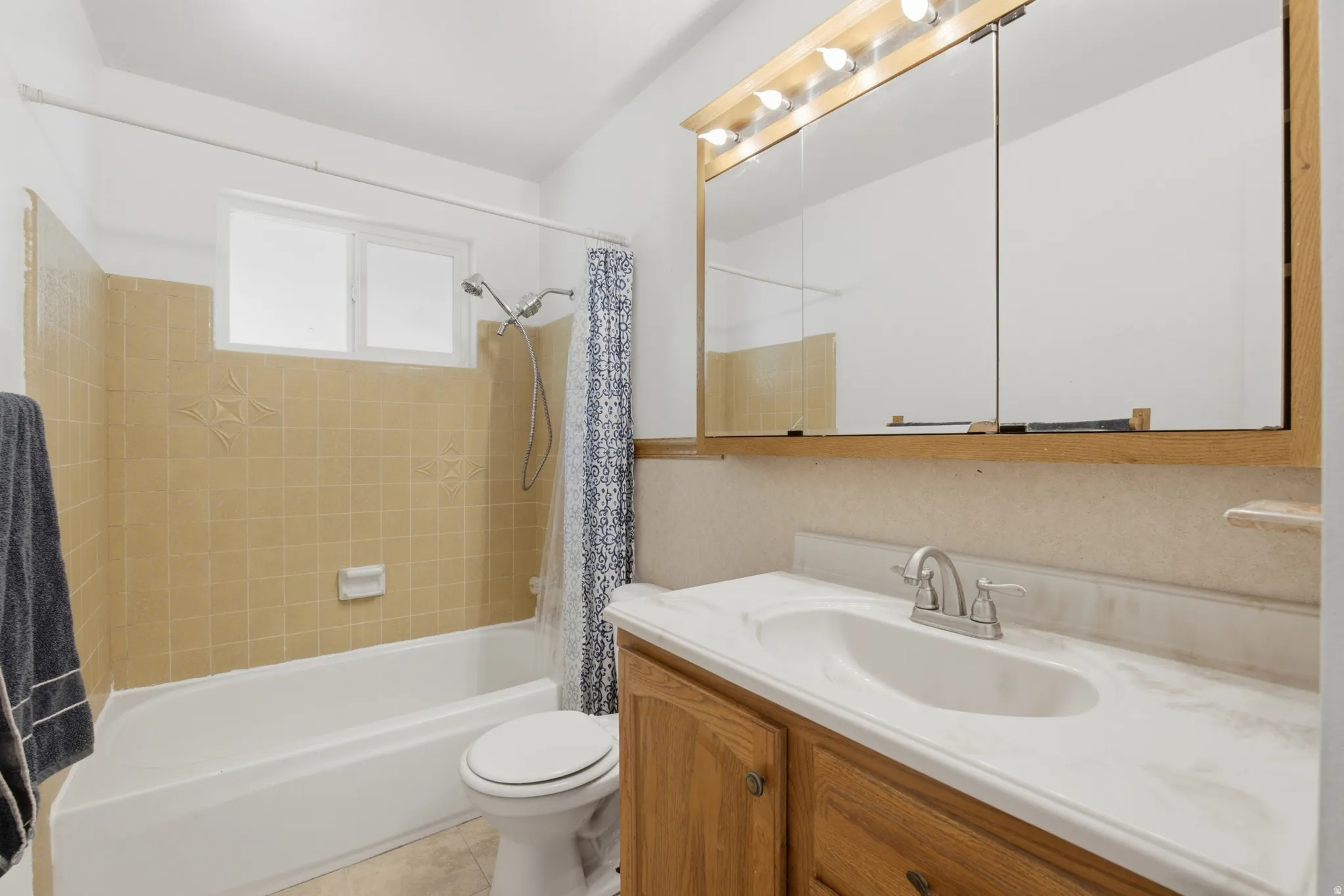 Bathroom featuring a wood-finish vanity with an integrated sink and a cultured marble countertop