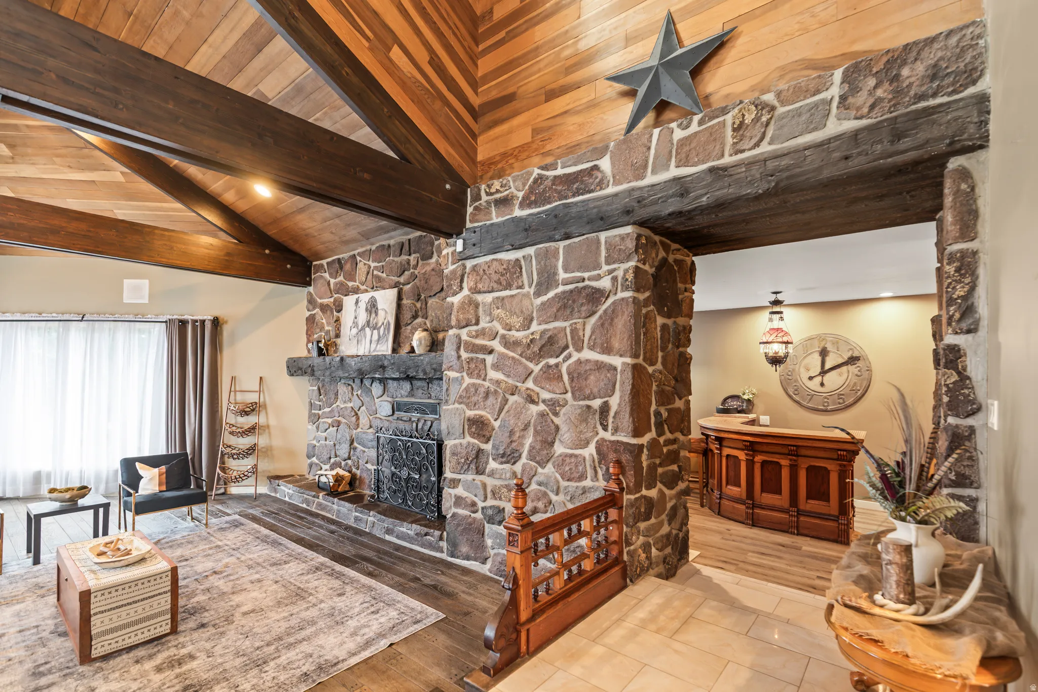 Stone-clad fireplace with a substantial hearth and decorative metal screen