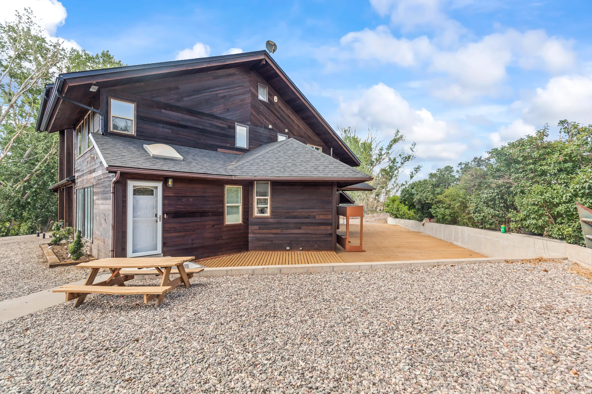 Multi-level wood-sided exterior featuring a gabled roof and white-framed windows