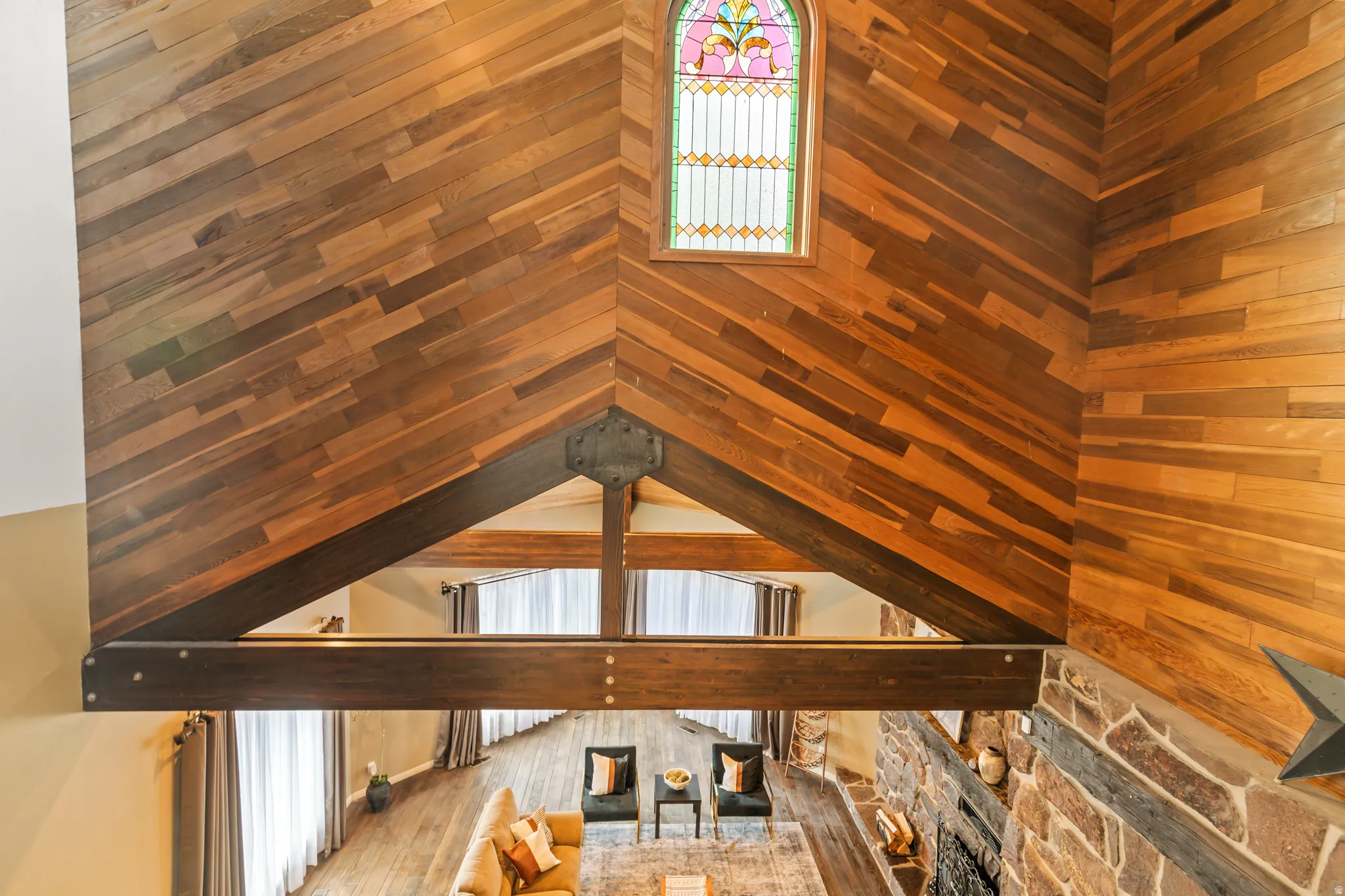 Vaulted wood-paneled ceiling with diagonal wood-finish planks and exposed structural beams