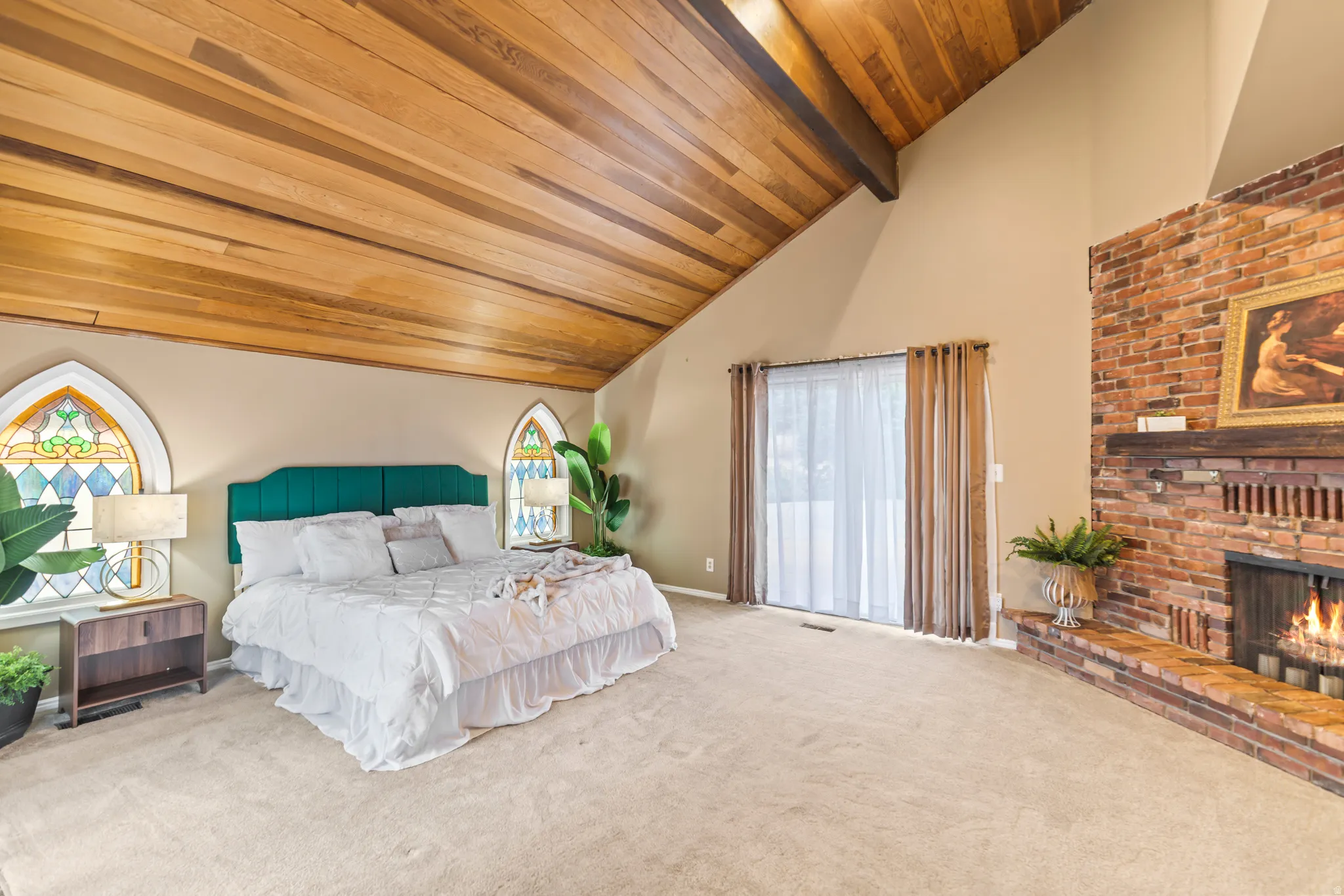 Vaulted wood-paneled ceiling with exposed beams, stained glass arched windows, and a full-height brick fireplace