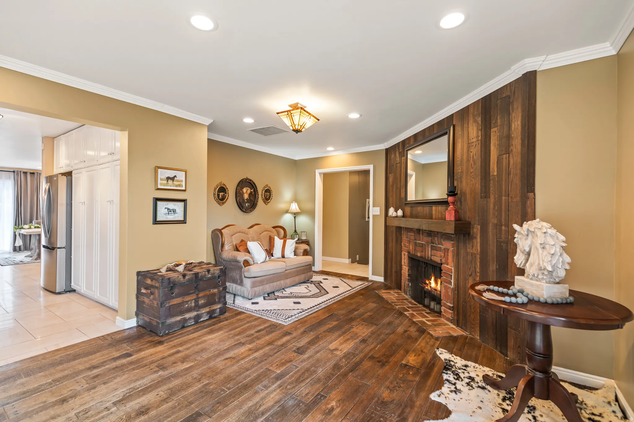 Living area featuring a brick fireplace with wood mantel, recessed lighting, and wood-finish flooring
