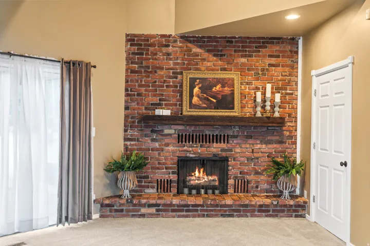 Brick fireplace with a wood mantel and hearth