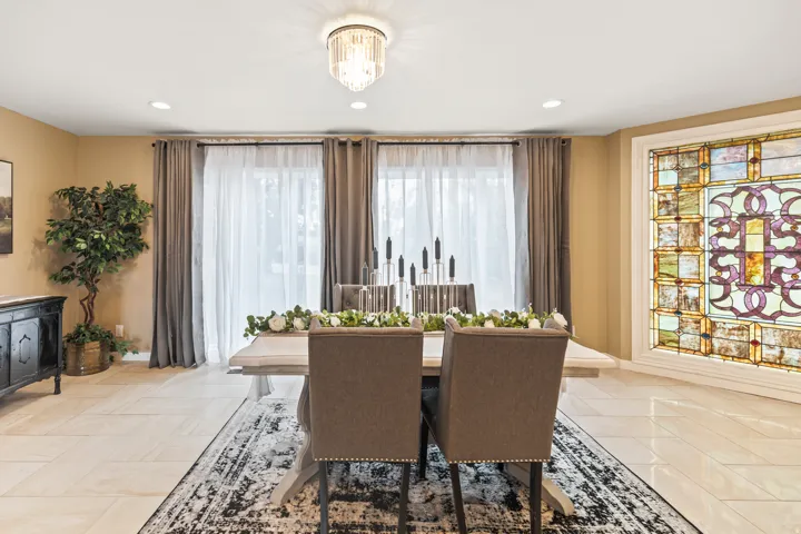 Spacious room featuring a decorative stained-glass window, recessed lighting, and a contemporary chandelier