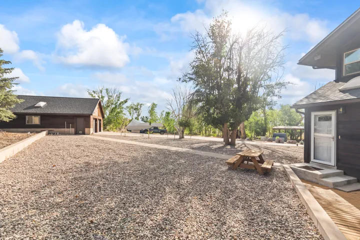 Expansive gravel driveway featuring multiple structures