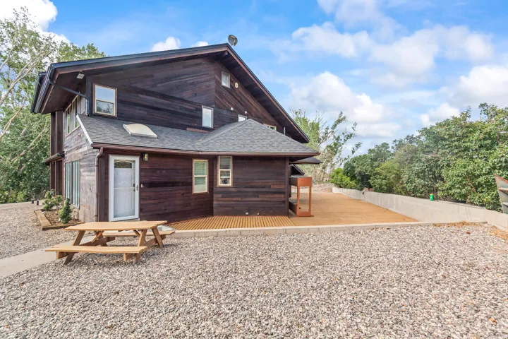 Multi-level wood-sided exterior featuring a gabled roof and white-framed windows