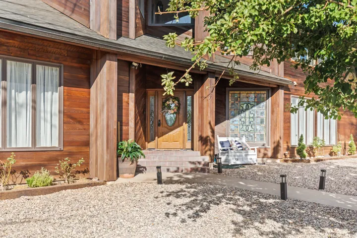 Wood-sided exterior featuring a prominent front entrance with a wooden door and sidelights