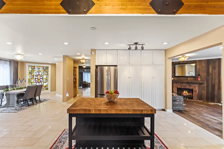 Butcher block island with open shelving and white paneled cabinetry