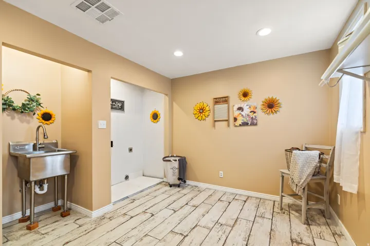 Utility room featuring wood-finish flooring, recessed lighting, and a stainless steel utility sink with a high-arc faucet