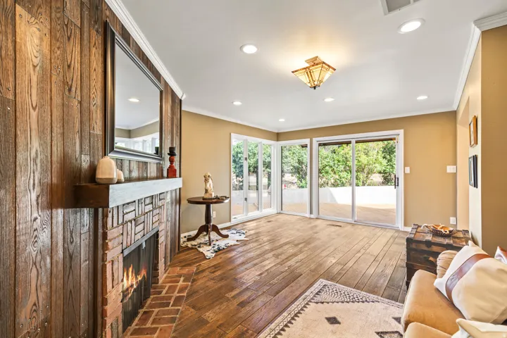 Brick fireplace with a wood-plank accent wall and floating mantel