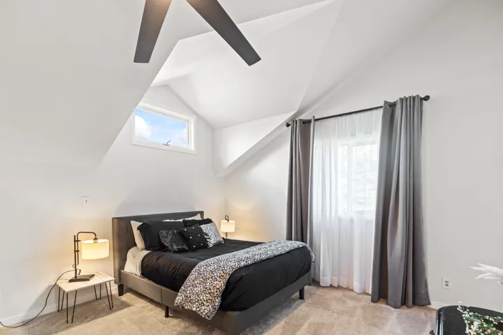 Bright bedroom with vaulted ceilings and a ceiling fan