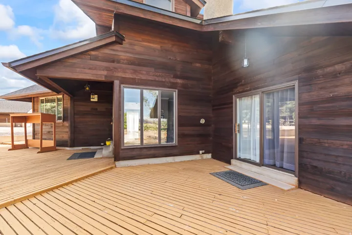 Expansive outdoor deck featuring wood-finish flooring and direct access to the interior via sliding glass doors