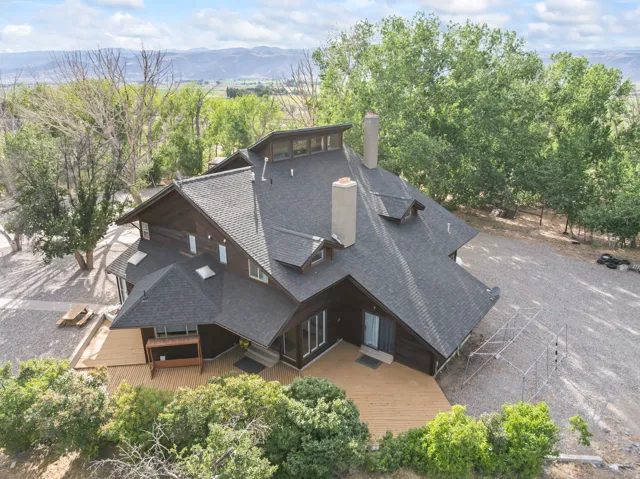 Multi-level residence featuring dark wood siding and a prominent asphalt shingle roof