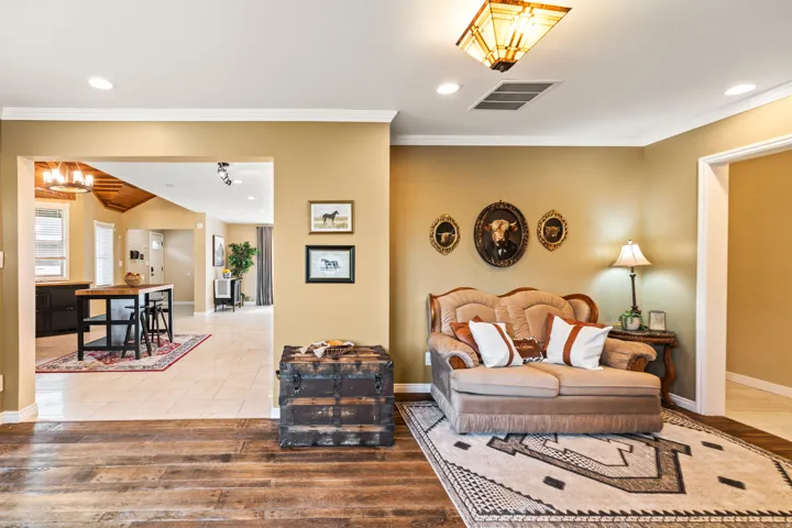Warm interior space featuring wood-finish flooring, light tan wall color, and white crown molding