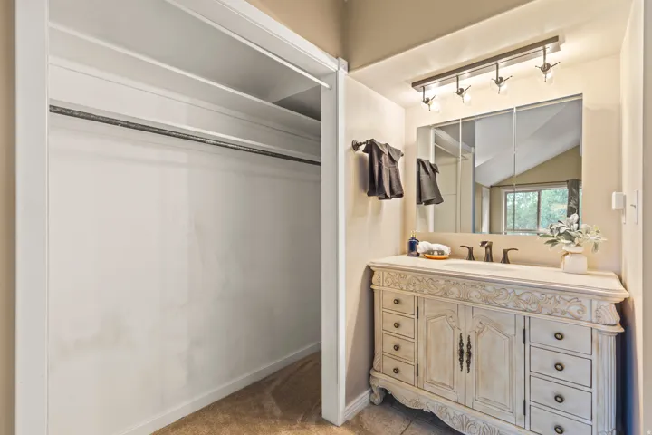 Carved vanity with integrated sink, bronze faucet, and coordinating light fixture