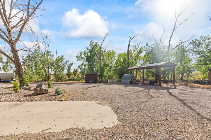 Gravel lot with a concrete pad and a metal-roofed carport
