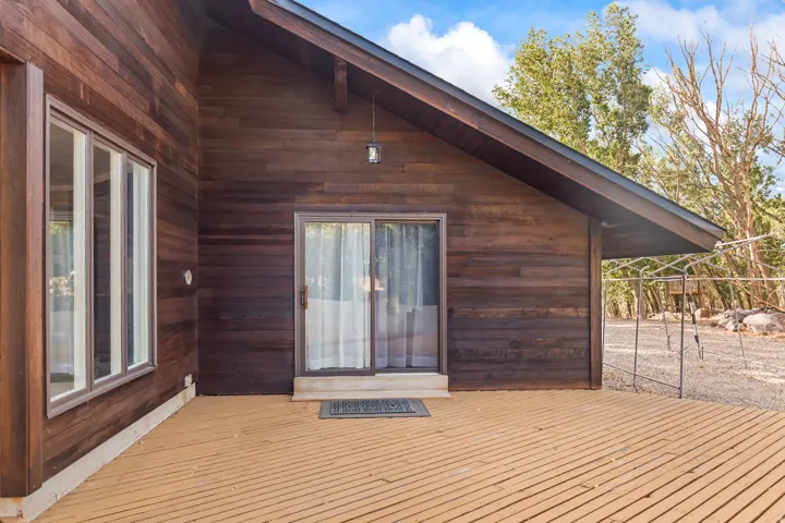 Wood-clad exterior featuring a pitched roofline, large window array, and sliding glass door