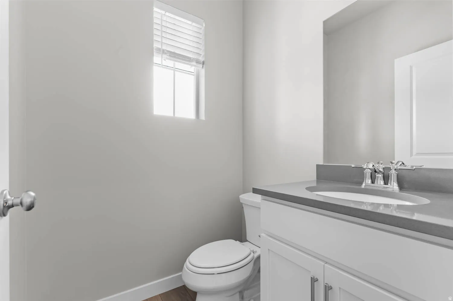 Bathroom featuring a single vanity with a gray countertop, an undermount sink, and a chrome faucet
