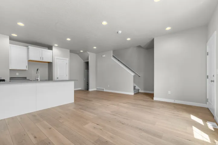 Open-concept living space featuring wood-finish flooring, recessed lighting, and white trim