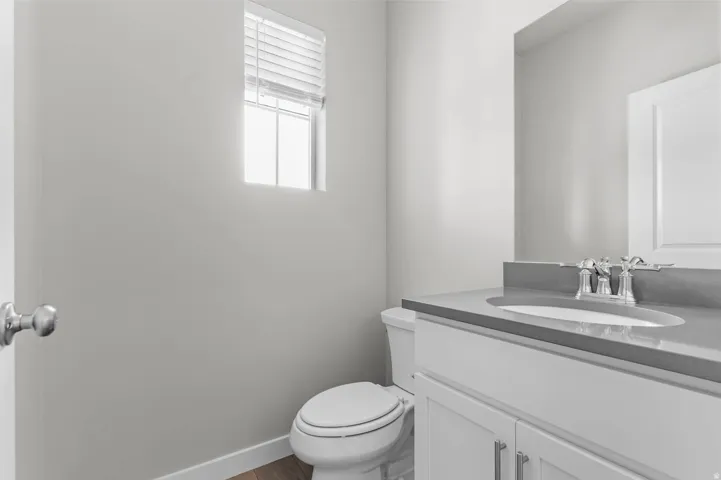 Bathroom featuring a single vanity with a gray countertop, an undermount sink, and a chrome faucet