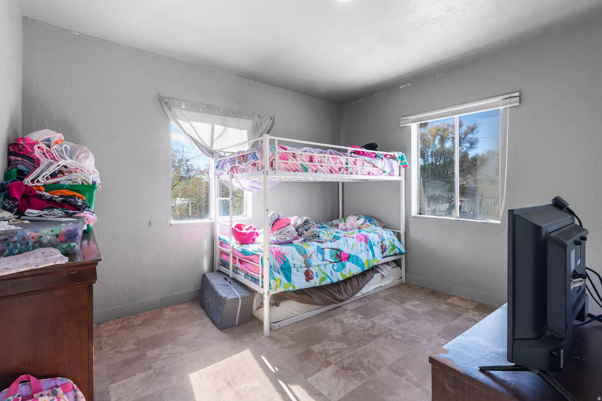 Room with two windows, light gray walls, and wood-finish flooring