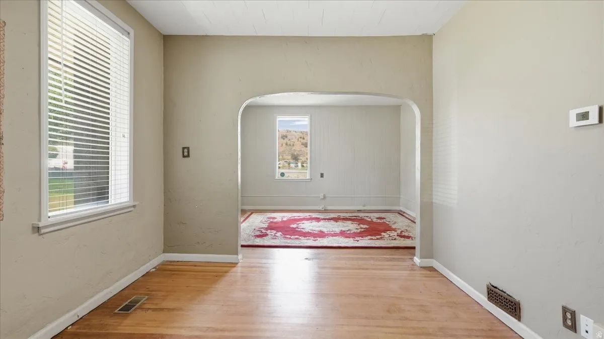 Hardwood flooring extending through an arched entryway