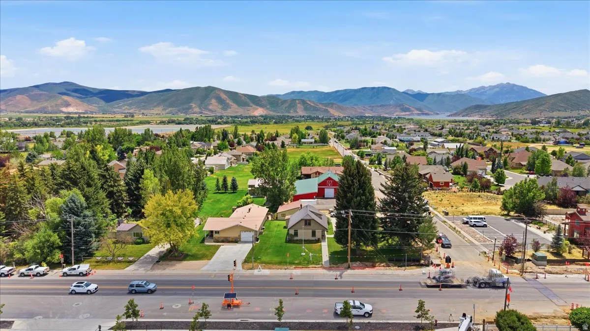 Aerial perspective showcasing a residential neighborhood with varied architectural styles, mature landscaping, and mountain backdrops