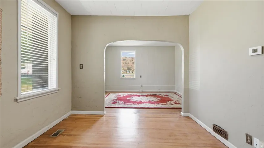 Hardwood flooring extending through an arched entryway