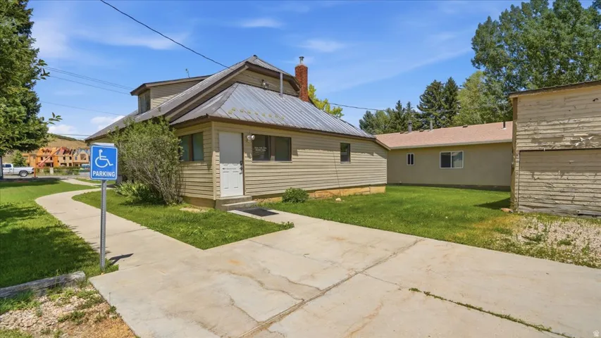 Property exterior featuring siding, a metal roof, and a visible chimney