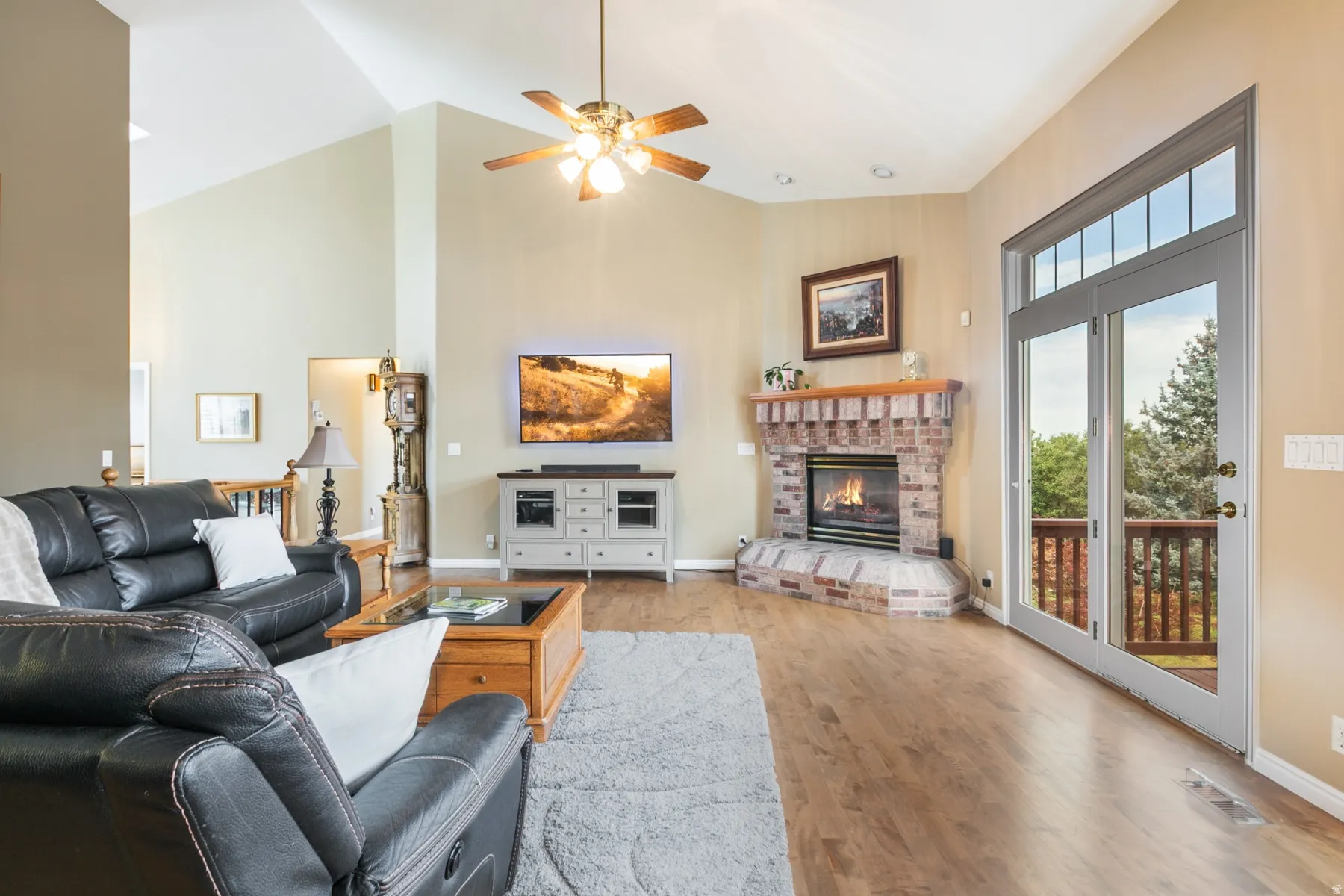 Spacious living area featuring vaulted ceilings and wood-finish flooring