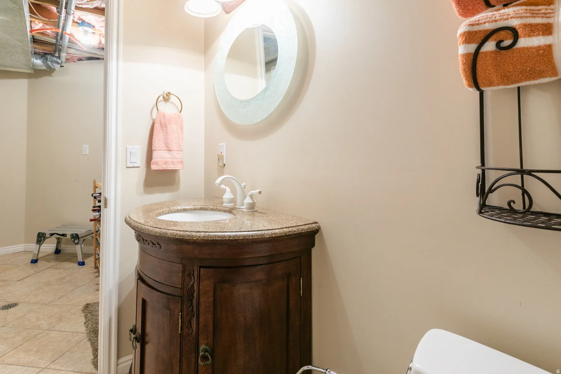 Vanity featuring a curved wood-finish base, integrated basin, and speckled countertop
