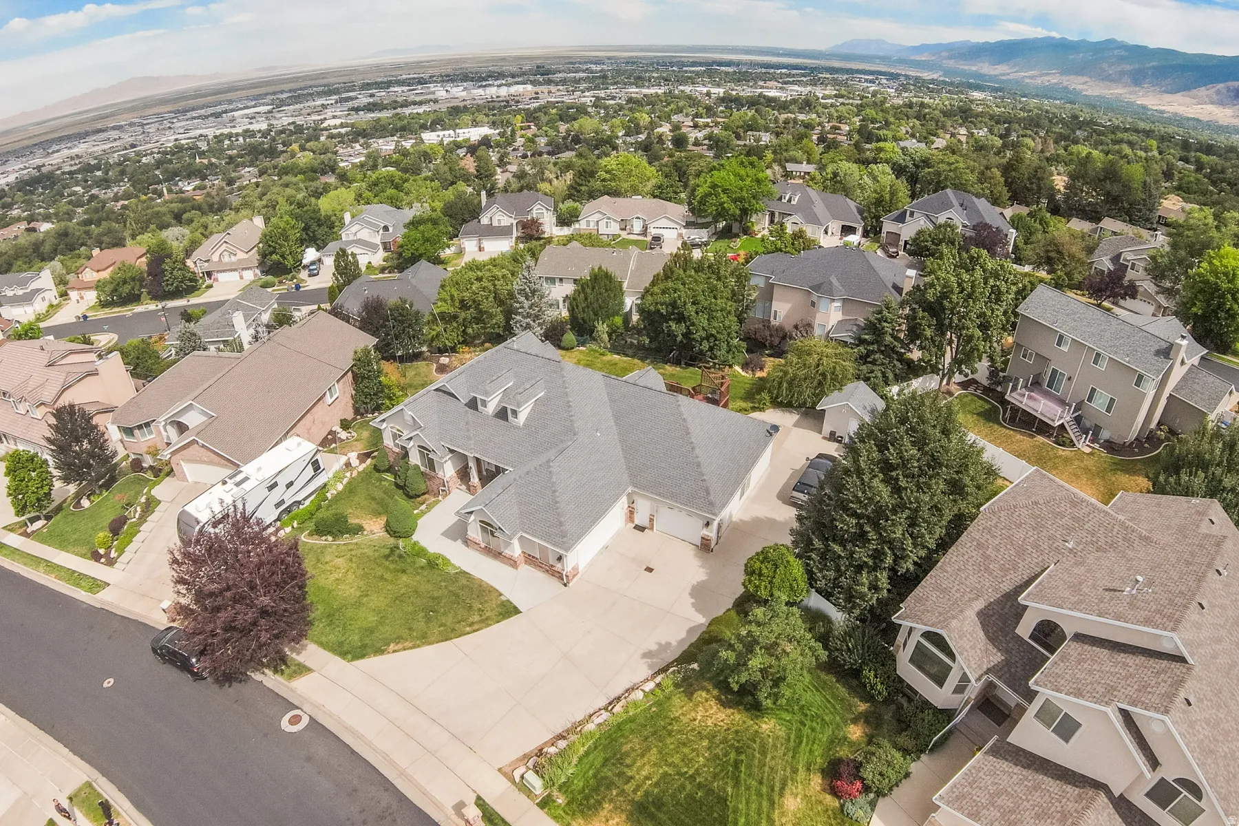 Suburban residential area featuring mature trees and a distant mountain range
