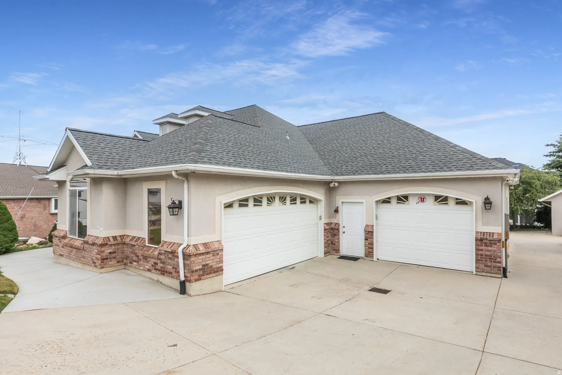 Two-car garage with arched doorways and contrasting brick and stucco exterior