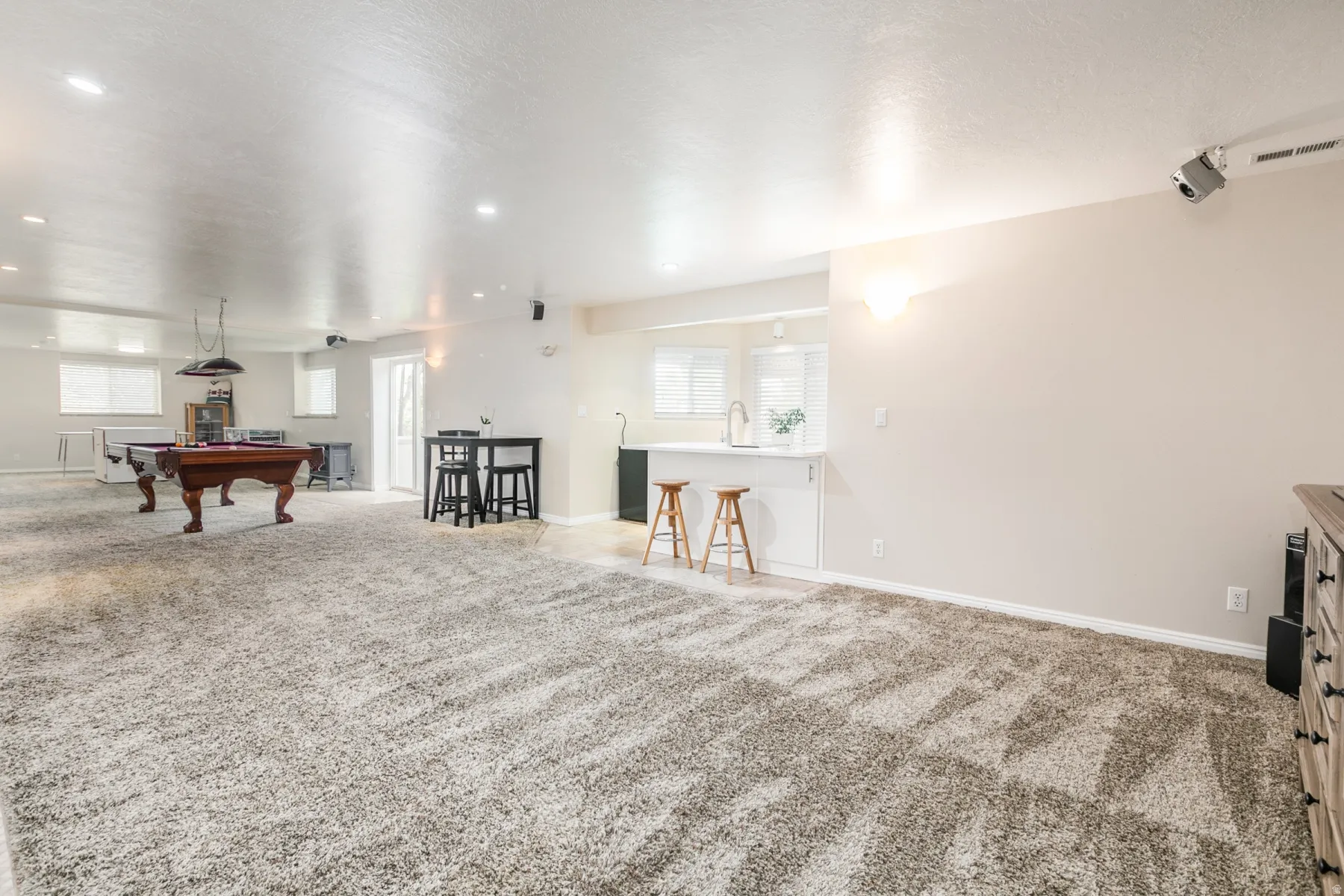 Spacious finished basement featuring light gray carpet flooring and recessed lighting