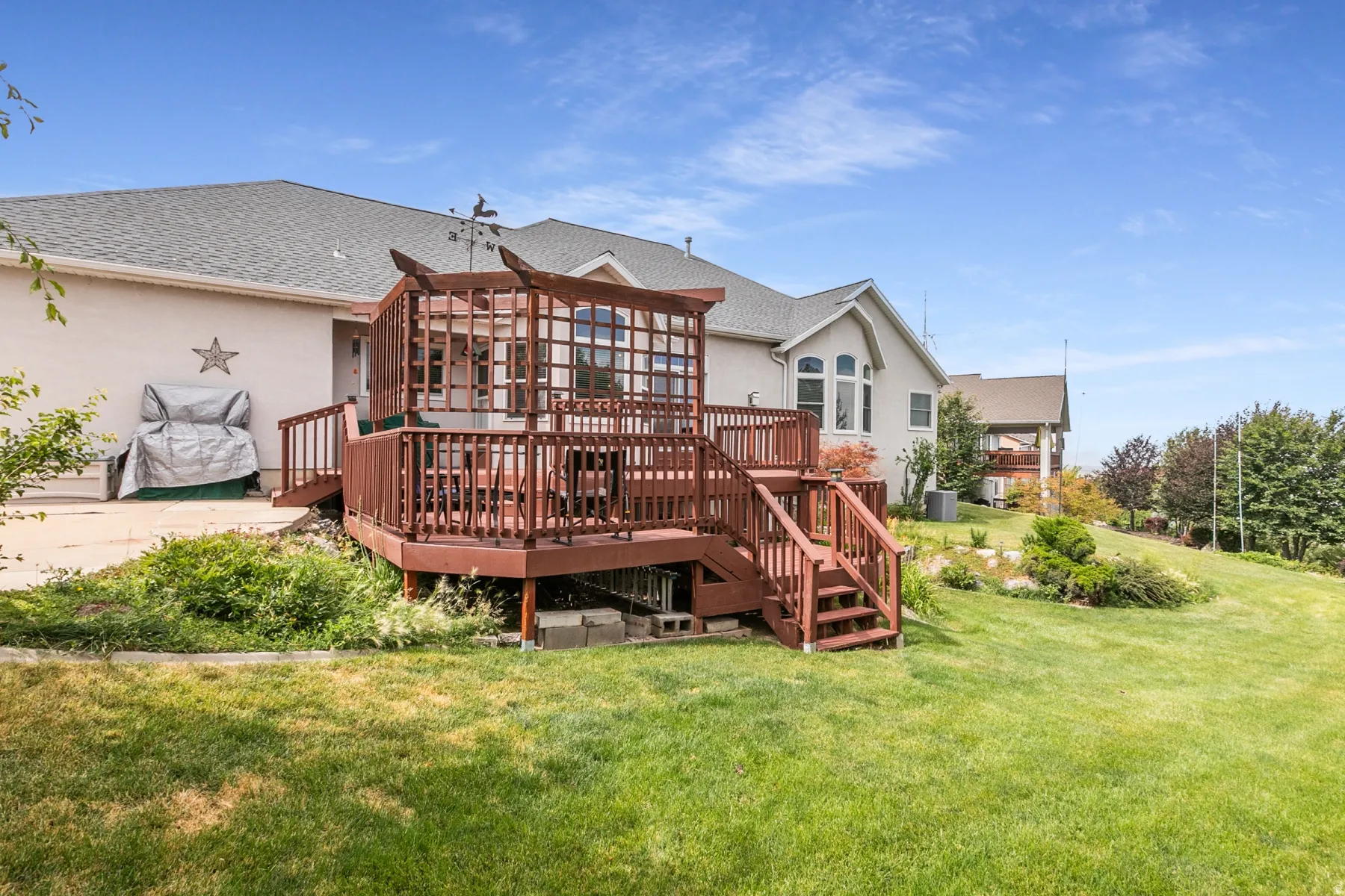 Multi-level exterior deck with a pergola, accessible via stairs